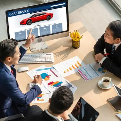 A group of business professionals in suits discussing car service data with charts and graphs, a computer displaying a car website.